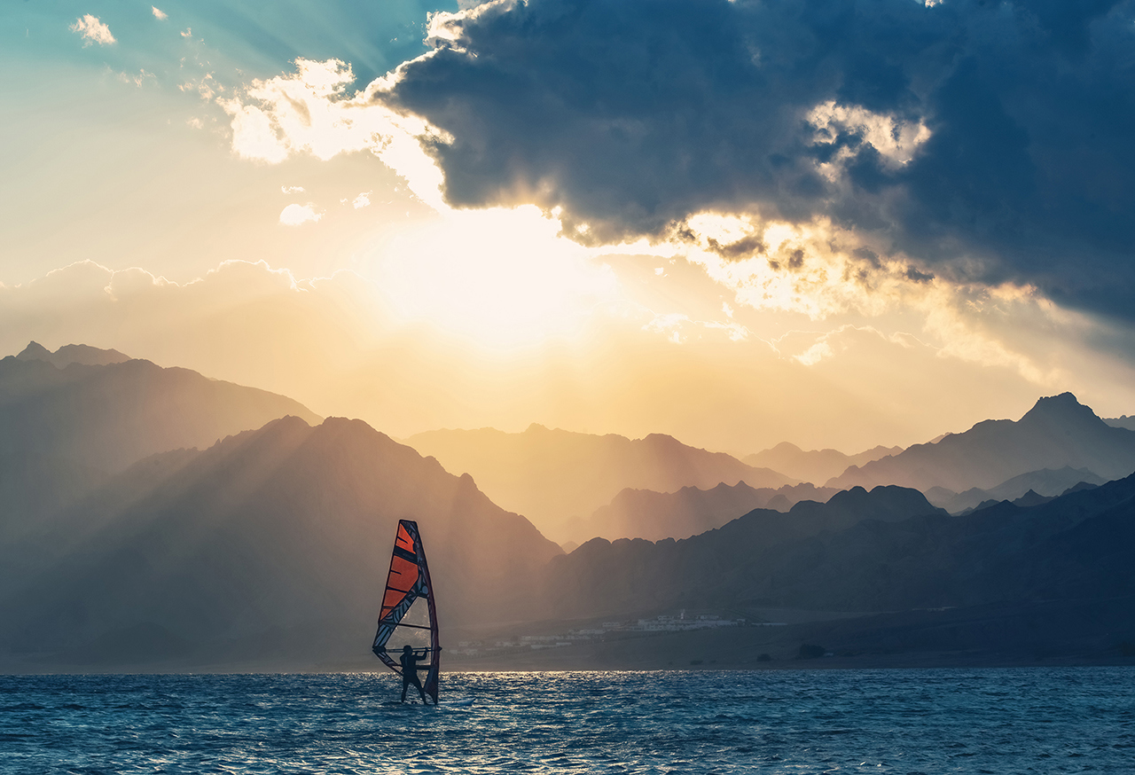 Windsurfing with mountains in the background
